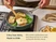 Caraway wooden utensil turning fish in a green ceramic small sauté pan.