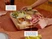 Hands carrying a wooden butcher block loaded with bowls of snacks and sliced meat.