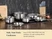 Caraway stainless steel cookware in several sizes arranged on a dark kitchen counter.