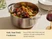 Caraway stainless steel Dutch oven serving a meat and vegetable dish on a dining table.