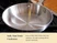 Caraway empty stainless steel fry pan on a stove, showing its polished interior.