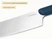 Caraway close-up of a stainless steel kitchen knife blade and Navy handle.