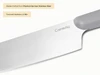 Caraway close-up of a stainless steel kitchen knife blade and Gray handle.
