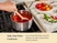 Hand stirring tomato sauce in a stainless steel sauce pan on a stove.